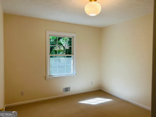 an empty room with closet and a chandelier fan