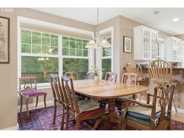 a dining room with furniture a rug and a floor to ceiling window