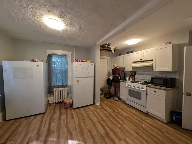 a kitchen with refrigerator cabinets and wooden floor