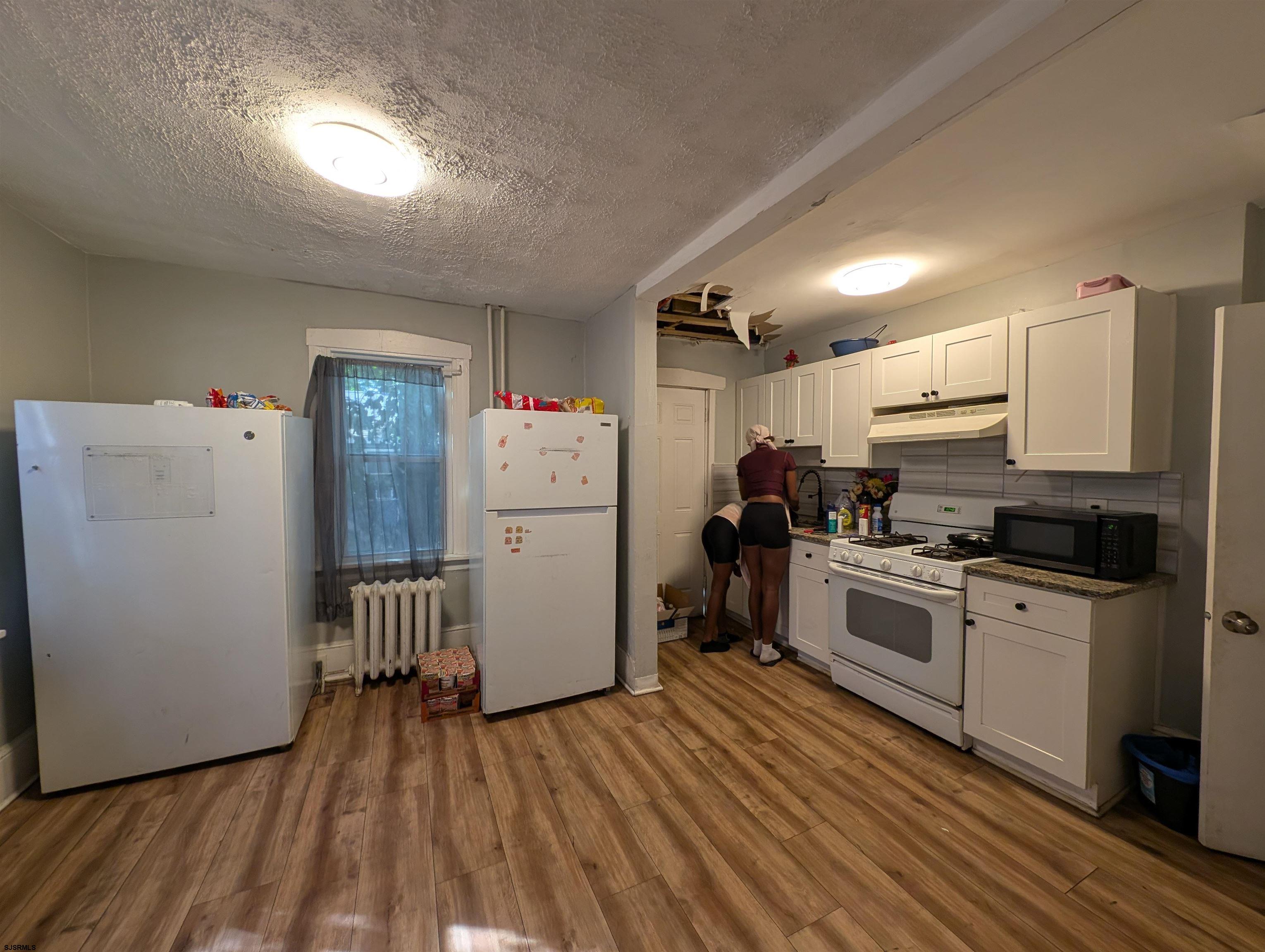 237 Guard Place Pleasantville, NJ 08232 - Photo 14 of 16 a kitchen with refrigerator cabinets and wooden floor