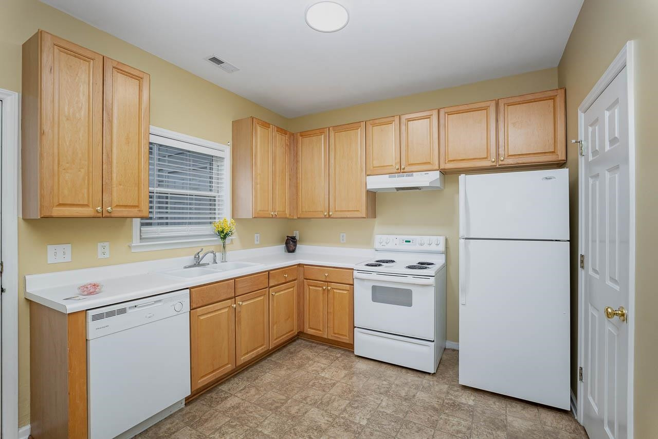213 Dairy Road Clayton, NC 27520 - Photo 13 of 31 a kitchen with a sink a refrigerator a window and cabinets