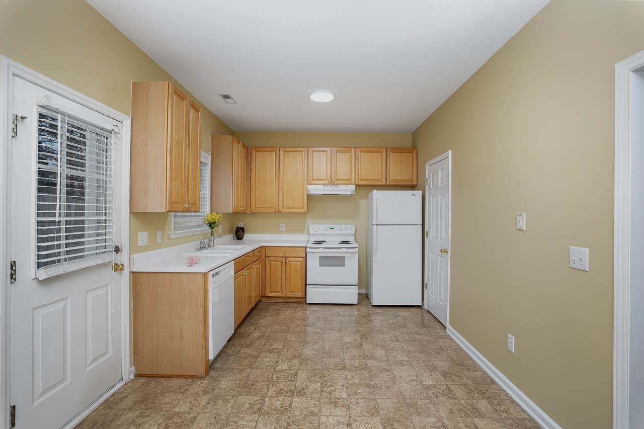 213 Dairy Road Clayton, NC 27520 - Photo 15 of 31 a kitchen with a stove a sink and a refrigerator