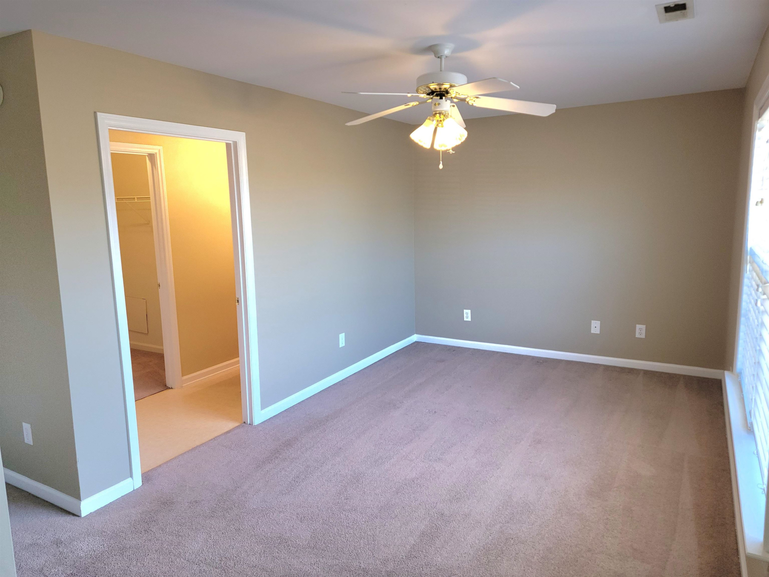 213 Dairy Road Clayton, NC 27520 - Photo 24 of 31 an empty room with a chandelier fan and a large window