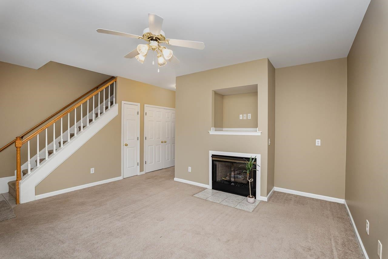213 Dairy Road Clayton, NC 27520 - Photo 10 of 31 a view of an empty room with chandelier fan and fire place