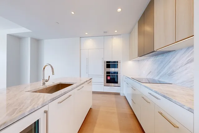 a view of a kitchen with kitchen island stainless steel appliances refrigerator sink and cabinets