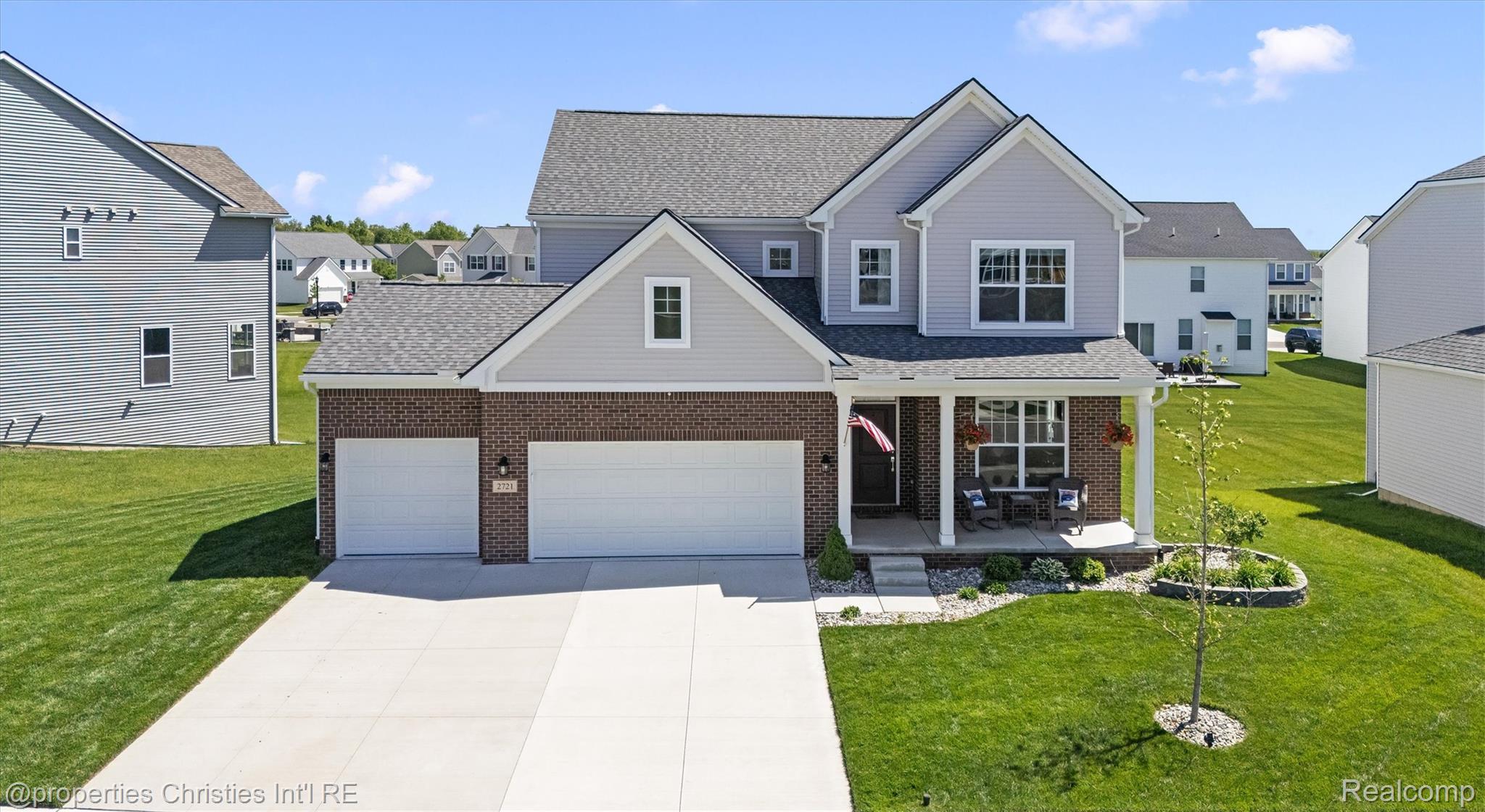 2721 Maize Loop Saline, MI 48176 - Photo 3 of 52 Traditional-style home featuring a porch, a front lawn, concrete driveway, and brick siding