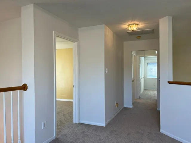 a view of a hallway to rooms