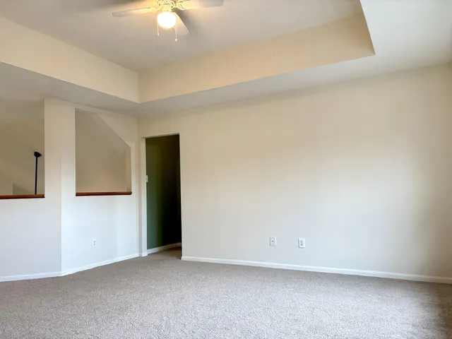 an empty room with a ceiling fan and closet area
