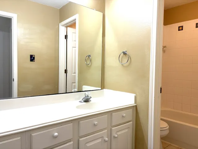 a bathroom with a granite countertop sink a mirror and a bathtub
