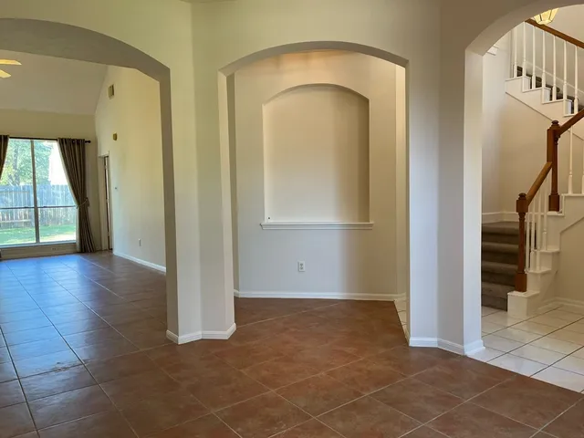 a view of a hallway with wooden floor and a living room