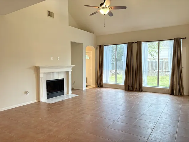 a view of an empty room with a fireplace and a large window
