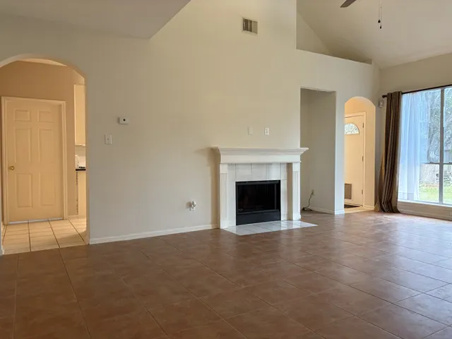 a view of empty room with wooden floor and fireplace