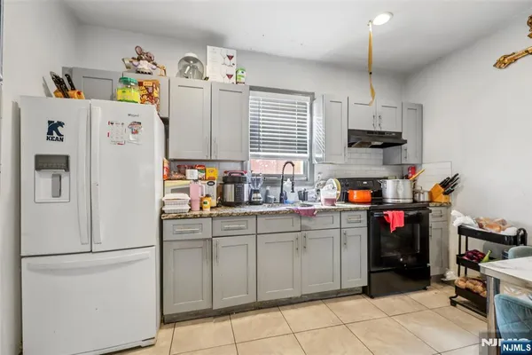 a kitchen with stainless steel appliances a white refrigerator a sink and a refrigerator