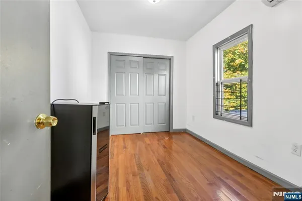 a view of an empty room with closet and a window