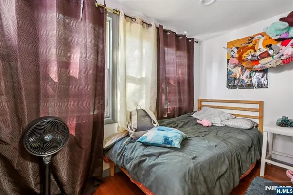 a bedroom with a bed a painting on the wall and a shower