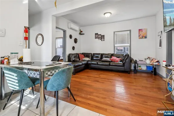 a living room with furniture a flat screen tv and a window