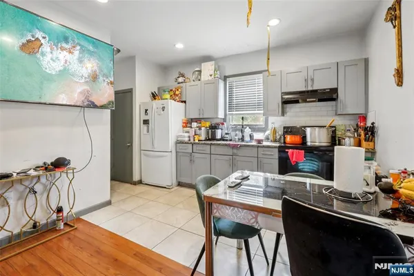 a kitchen with stainless steel appliances granite countertop a sink dishwasher a refrigerator and microwave with wooden floor
