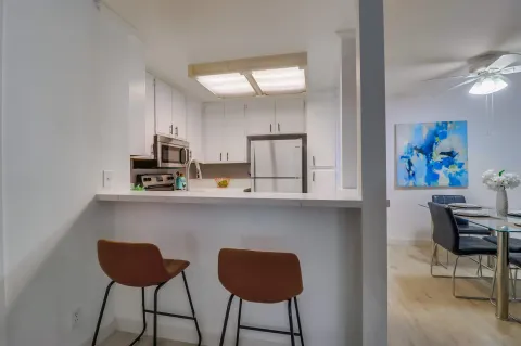 a view of kitchen with cabinets and chairs in it