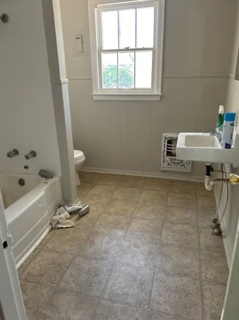 a bathroom with a bathtub and a window
