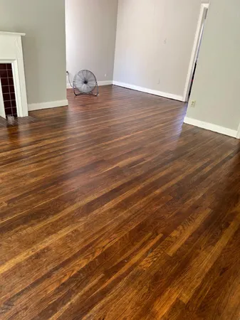 a view of empty room with wooden floor