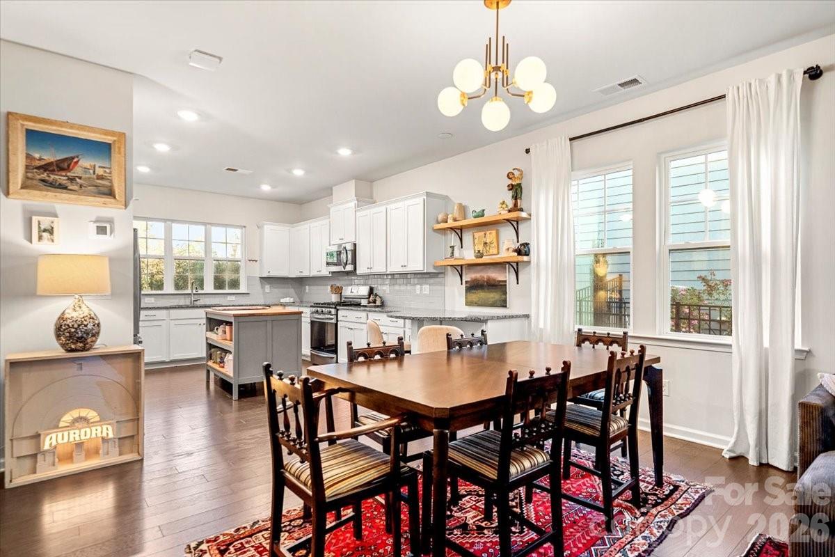 134 Dry Rivers Lane Mooresville, NC 28117 - Photo 5 of 29 a dining room with wooden floor a chandelier a glass table and chairs