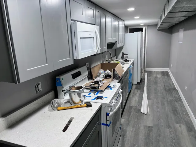 a kitchen with stainless steel appliances granite countertop a sink refrigerator and cabinets