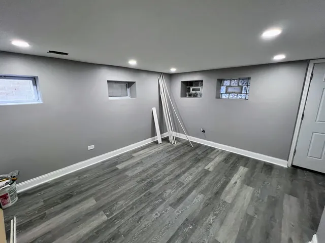 an empty room with wooden floor and window