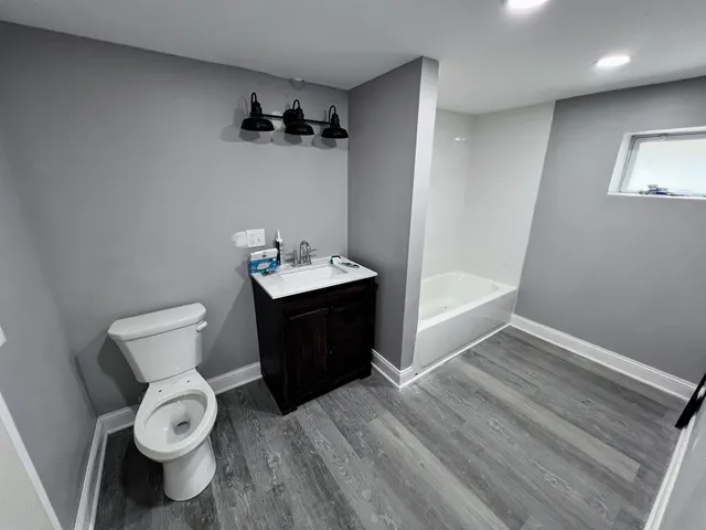 a bathroom with a toilet sink and mirror