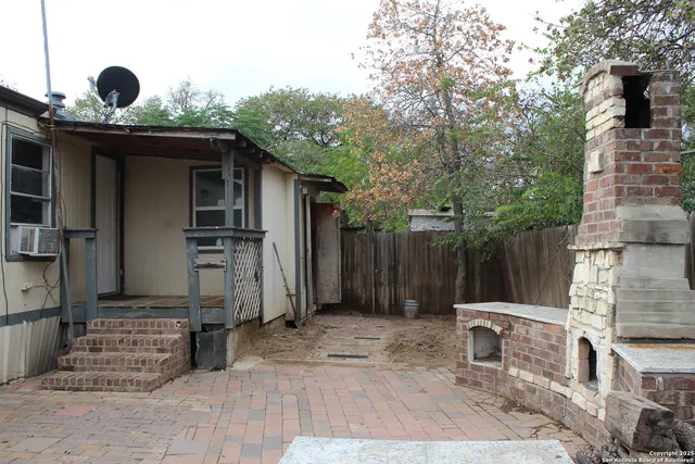 a backyard of a house with barbeque oven and outdoor seating