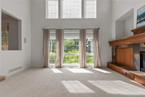 a view of a livingroom with a fireplace and large windows
