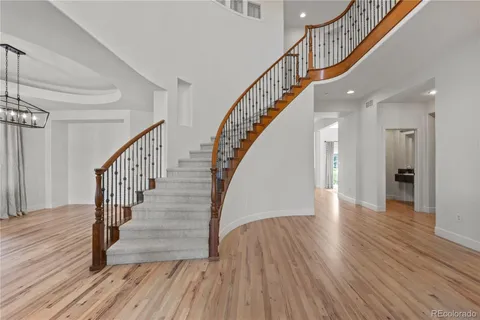a view of staircase with wooden floor and a chandelier