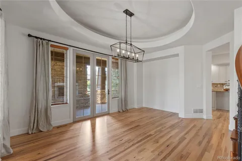 a view of a room with wooden floor chandeliers and kitchen