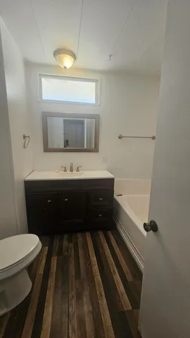 a bathroom with a sink a toilet a mirror and shower