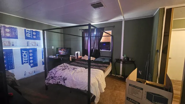 a bedroom with a bed and a mirror