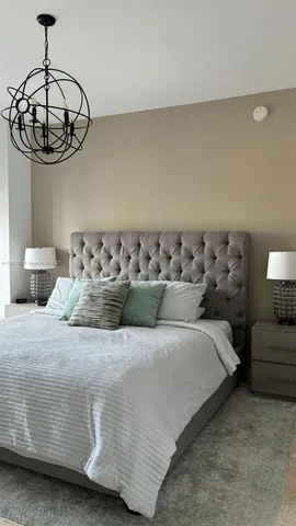 a bedroom with a bed and chandelier