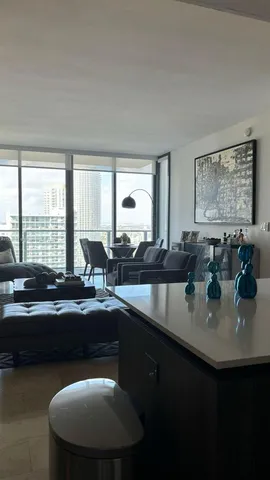 a kitchen with sink and view of living room