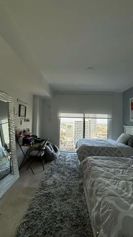 a bedroom with bed couch and window