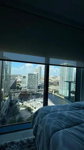 a large bed sitting in a bedroom next to a large window