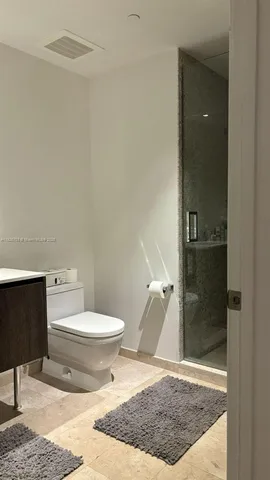 a bathroom with a toilet and a shower