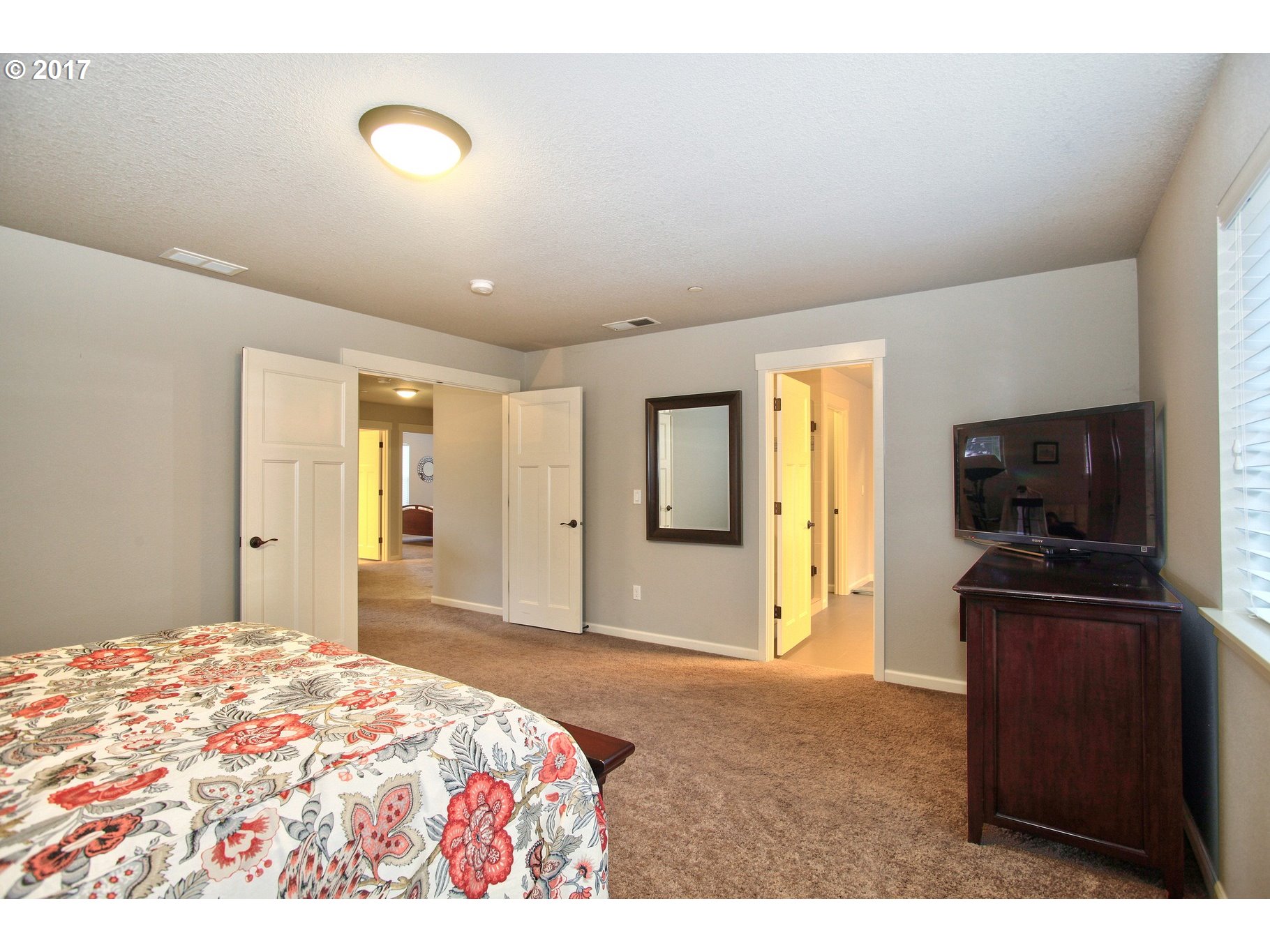 12723 Southwest Willow Point Lane Tigard, OR 97224 - Photo 12 of 27 a bedroom with a bed and a flat screen tv