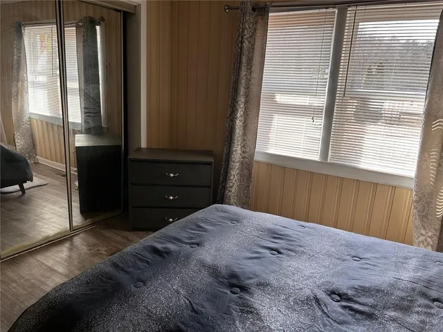 a bedroom with a bed and painting on the wall