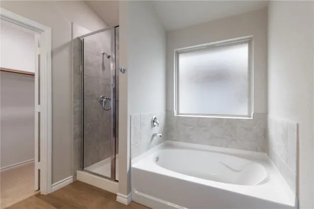 a white bath tub sitting next to a shower