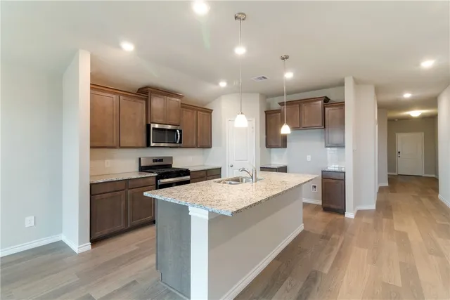 a large kitchen with stainless steel appliances granite countertop a large center island and a sink