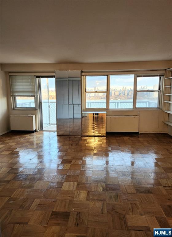 6600 Boulevard East, Unit 8A West New York, NJ 07093 - Photo 11 of 24 an empty room with wooden floor and windows
