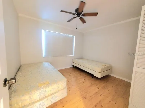 an empty room with a window and a ceiling fan