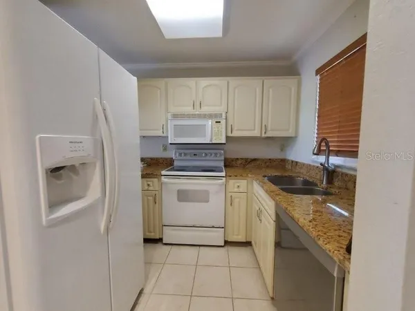 a kitchen with a stove sink and cabinets