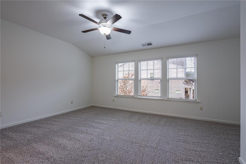 3207 Cyrus Point Lane Kennesaw, GA 30152 - Photo 21 of 24 an empty room with chandelier fan and windows