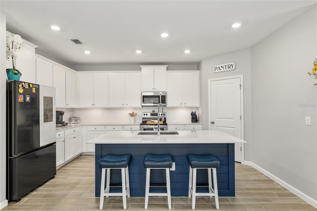 5688 Southwest 92nd Place Ocala, FL 34476 - Photo 17 of 54 a kitchen with kitchen island granite countertop a sink cabinets and stainless steel appliances
