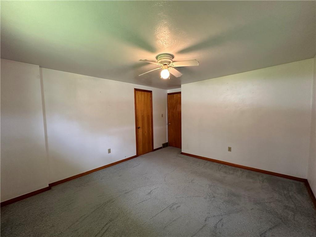 102 Schall Road Kittanning, PA 16201 - Photo 9 of 30 an empty room with a chandelier fan and windows