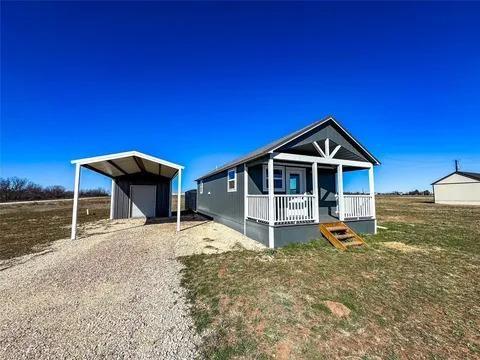 323 Blue Cat Boulevard Haskell, TX 79521 - Photo 2 of 18 Compact home featuring a covered front porch with white railing, blue siding, and white trim accents